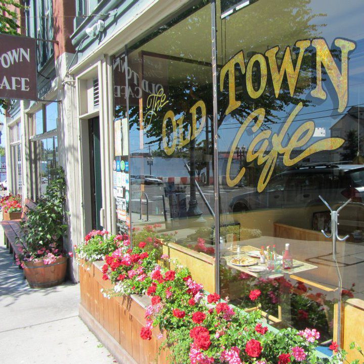 Cafe window with planter box in front of it and writing on it that reads Old Town Cafe