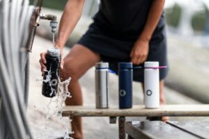 Man filling water bottles to have while exercising